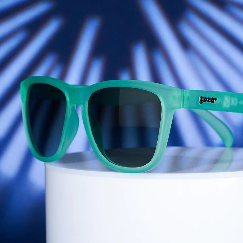 Product closeup of mint green square-shaped sunglasses, with dark green gradient lenses.