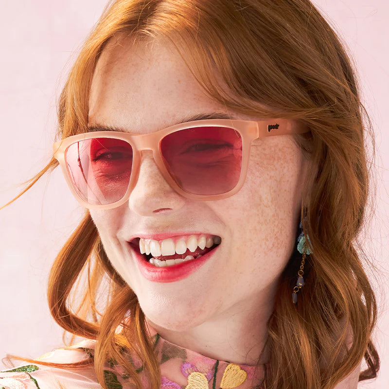 Women&#39;s style and fit showcase of pink square-shaped sunglasses with pink gradient lenses.