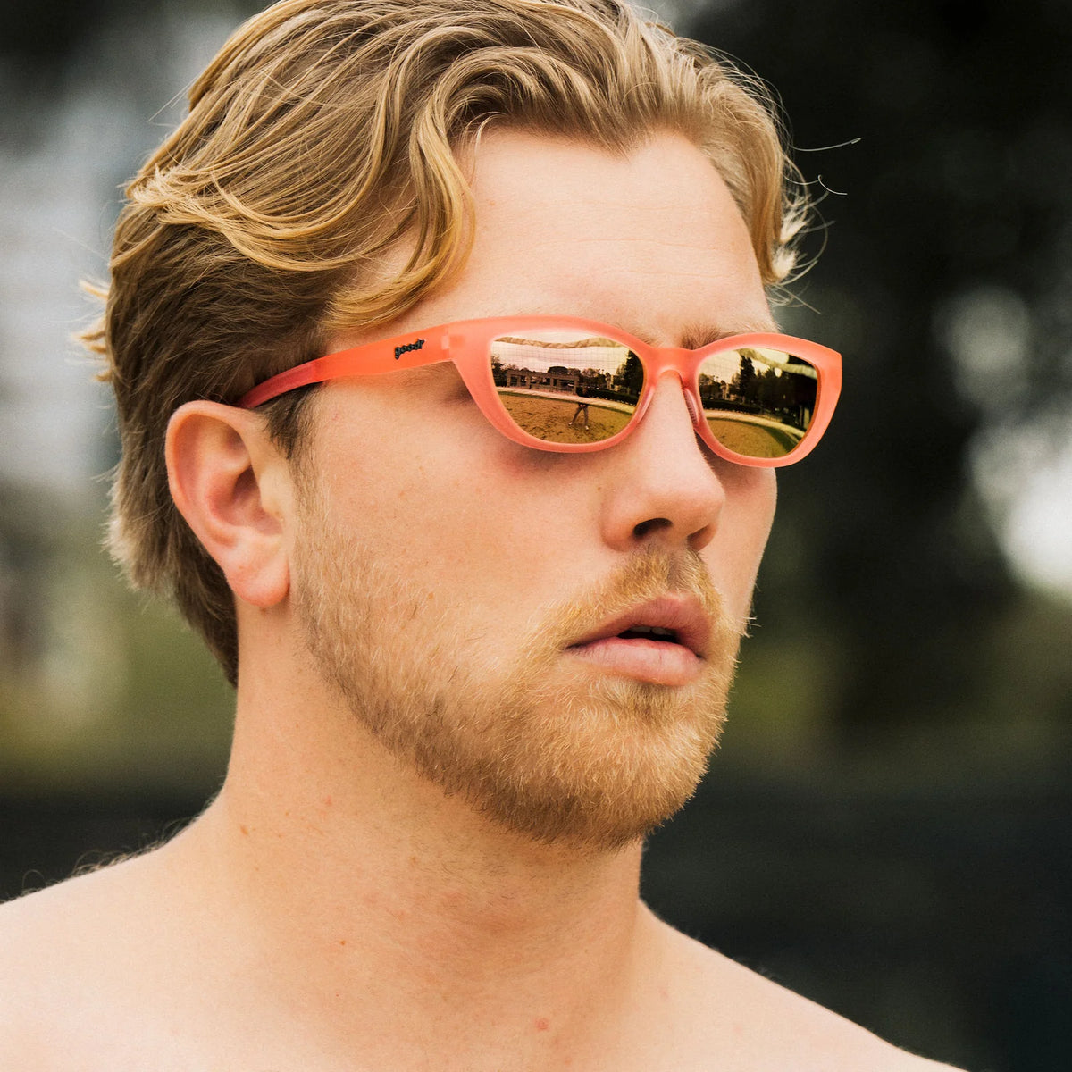 Fit and style showcase of pink sunglasses with a cat-eye shape. Pink champagne mirrored lenses.